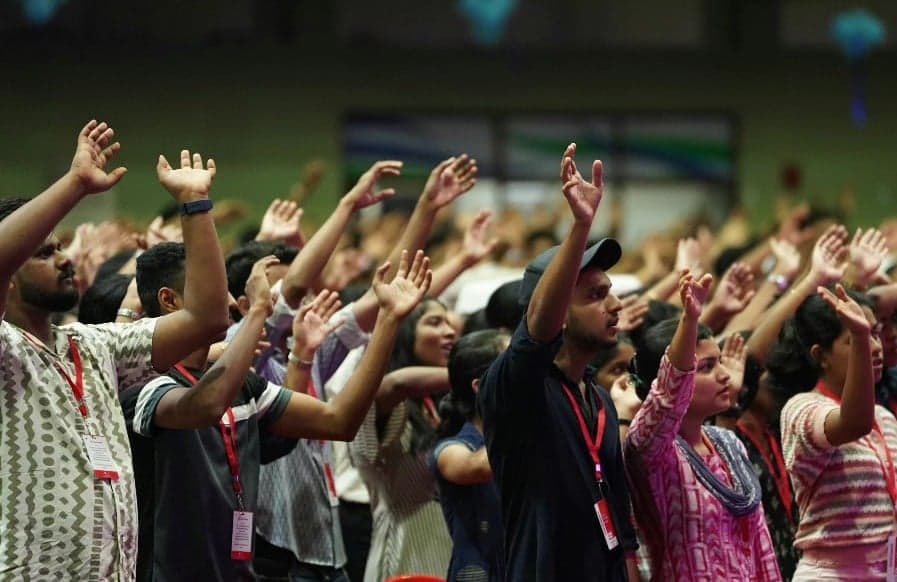 Students with hands raised during praise